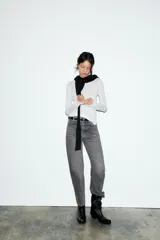 Jeans de tiro alto con corte mom fit, cinco bolsillos y cierre frontal con cremallera y botón metálico.