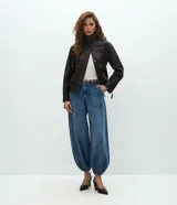 Pantalón de jean estilo aladín con cintura alta, corte amplio y piernas voluminosas que se ajustan en el bajo con puño elástico. Cuenta con pretina con presillas, cierre tradicional y bolsillos funcionales.
