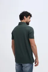 Remera polo bordó con textura sutil, cuello y puños acanalados con línea oscura de contraste, cierre frontal parcial de dos botones y logo bordado en el pecho.
