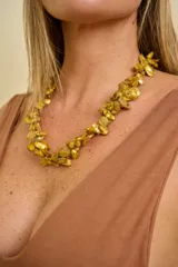 Collar corto de diseño voluminoso, elaborado con abalorios irregulares en tonos dorados y mostaza con acabado nacarado.