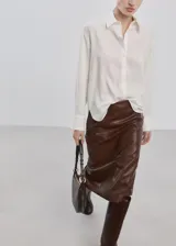 Camisa oversize blanca de lyocell, con mangas largas y cierre frontal de botones.