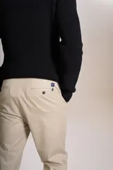 Sweater de punto con textura acanalada, color negro, de cuello redondo y manga larga. Presenta un pequeño logo bordado en el pecho.