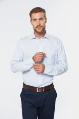 Camisa de vestir blanca de manga larga, con cuello clásico y cierre frontal de botones.