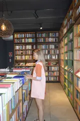 Camisola corta con cuello camisero y mangas cortas, con diseño a rayas verticales en tonos naranja, rosa y celeste.