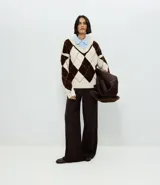 Suéter de punto con diseño de cuadros argyle en tonos marrón y crema, cuello en V y mangas largas con sisa caída.