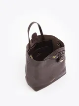 Cartera tipo tote bag pequeña de cuero vacuno negro con diseño de abejas grabadas en bajo relieve. Cuenta con doble asa de mano, correa ajustable y un tag colgante con dije metálico en forma de abeja.