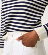 Sweater de punto de manga larga, con rayas horizontales en azul marino y blanco. Presenta cuello redondo ligeramente elevado y puños y ruedo en color blanco liso.