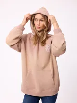 Canguro oversize color negro con efecto degradado, capucha, bolsillo frontal tipo canguro y puños elásticos. Presenta un parche con logo en la manga.