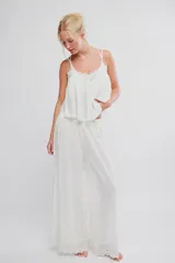 Musculosa blanca de tela liviana con caída amplia, escote en V con aplique de encaje, tirantes finos regulables y diseño corto.