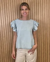 Musculosa de lino color celeste claro, con cuello redondo y mangas cortas con volados.