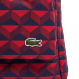 Mochila Lacoste Neocroc de color rojo y azul con estampado geométrico en 3D. Cuenta con un compartimento principal con cierre de doble cursor, un bolsillo frontal con cierre y tiradores de cordón, asa superior de mano y el clásico logo del cocodrilo bordado en la parte inferior.