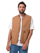 Chaleco de lona color marrón Caterpillar, con cierre frontal de cremallera, cuello tipo bomber en tejido elástico, bolsillos delanteros y parche con logo de la marca.