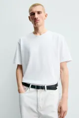 Camiseta regular fit de color beige, confeccionada en tejido de algodón compacto, con cuello redondo y manga corta.