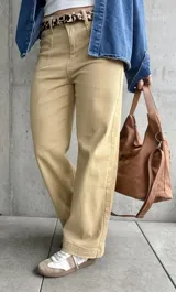 Pantalón de jean color beige, de corte recto y tiro alto, con bolsillos delanteros y traseros.