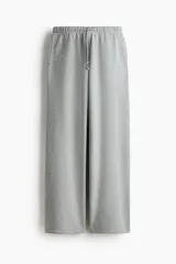 Pantalón de jogging de corte holgado y piernas amplias, confeccionado en felpa con interior cepillado. Presenta cintura elástica con cordón de ajuste y bolsillos laterales discretos.