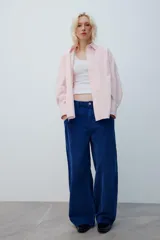 Pantalón de tiro medio confeccionado en pana color azul, de corte baggy con pierna ancha, estilo clásico de cinco bolsillos y cierre frontal con cremallera y botón metálico.