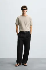 Camiseta de punto de corte relajado (relaxed fit) con cuello redondo y manga corta. Tejido en hilatura de algodón y lino, con rayas horizontales en tonos beige y marrón claro. Los acabados del cuello y los puños son en un tono marrón más oscuro a contraste.