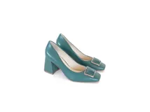 Zapato de cuero color verde, estilo stiletto con punta cuadrada y aplique metálico en el empeine. Posee un taco ancho de altura media con textura geométrica.