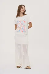 Remera de manga corta y cuello redondo color blanco, con estampa frontal multicolor de ilustraciones de estilo gráfico.