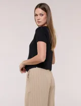 Cardigan corto de tejido de punto fino con hilo brillante de lurex y destellos metalizados. Presenta escote en V pronunciado, mangas cortas, cierre frontal con botones a tono y ruedo con terminación en pico en el frente.