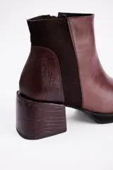 Botin de cuero vacuno color marrón, con taco cuadrado de 6 cm y diseño combinado que incluye texturas lisas y efecto reptil en el talón y el taco.