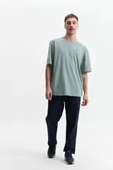 Remera de manga corta color crema, corte oversize, con cuello redondo y estampado con texto y diseño floral en el frente.