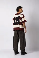 Remera tejida de manga corta con diseño de rayas horizontales anchas en color bordó y crema, de corte relajado y cuello redondo.