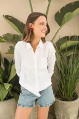 Camisa blanca de lino, de corte clásico, con cuello camisero, manga larga y bolsillo en el pecho.