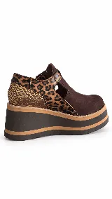 Guillerminas de cuero marrón chocolate, con detalles en animal print y textura dorada metalizada. Presentan una tira con hebilla metálica en el empeine, aberturas laterales y suela de plataforma corrida con franjas en contraste.