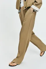 Pantalón recto de tiro bajo en color verde militar, con nervios marcados en la parte delantera, bolsillos frontales y cierre con cremallera, botón interior y ganchos.
