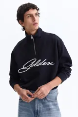 Buzo azul marino con cuello elevado, medio cierre frontal y hombros caídos. Presenta el texto "Golden" bordado en blanco en el pecho y puños y bajo de punto acanalado.