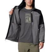 Campera técnica con capucha, confeccionada en tejido softshell con tecnología Omni-Shield. Presenta un diseño bicolor en gris y negro, cierre frontal completo, bolsillo vertical en el pecho y bolsillos laterales con cierre.