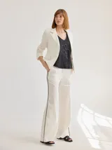Pantalon de lino de corte recto y tiro medio, color crudo con vivos laterales en contraste negro.