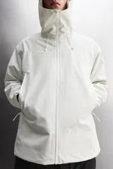 Cazadora deportiva de ajuste regular, confeccionada en tejido técnico de tres capas con membrana impermeable (resistencia al agua ≥15K) y costuras termoselladas. Presenta cuello subido con capucha ajustable, manga larga con puños ajustables con tira adherente, aberturas con cremallera termosellada en axilas para ventilación, bolsillos frontales con cremallera termofijada y bajo ajustable con elásticos laterales.