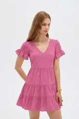 Vestido corto de viscosa color rosado, con escote en V, mangas cortas con volados y falda en capas escalonadas.