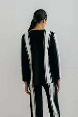 Sweater de punto negro con rayas verticales blancas y cuello redondo color marrón.