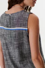 Top sin mangas de corte recto y holgado, confeccionado en tejido de lino con textura jaspeada en tono azul. Presenta cuello redondo y un diseño minimalista ideal para climas cálidos.