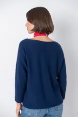 Sweater color beige claro, de corte holgado, manga larga y cuello redondo.