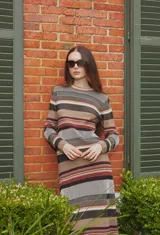 Sweater de punto con diseño de rayas horizontales en tonos tierra, cuello redondo y mangas largas.