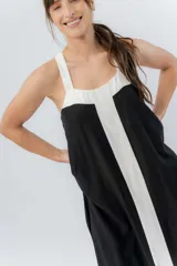 Vestido midi negro con panel frontal blanco, de corte amplio, escote recto y tiras anchas.