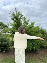 Cardigan tejido a mano color crudo, con solapa en el escote y punto delicado.