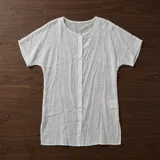 Camisa holgada blanca de manga corta y largo medio, confeccionada en mezcla de algodón, con cierre frontal de botones.