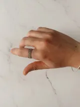 Anillo triple de acero quirúrgico, compuesto por tres bandas finas con texturas diferentes: una lisa, una con pequeñas esferas y una con diseño de bolitas.