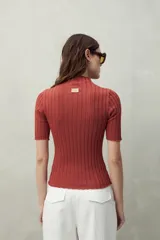 Top negro de manga corta tejido con textura acanalada, cuello alto y terminaciones onduladas.