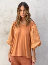 Blusa color terracota con mangas abullonadas.