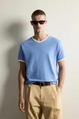 Camiseta de corte regular en color azul, con cuello en pico y bordes de las mangas en color amarillo a contraste.