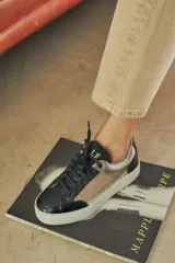 Championes urbanos con diseño de paneles en tonos verde oliva, negro y gris. Presentan una combinación de texturas que incluye cuero liso, gamuza y un panel con estampado de piel de serpiente en el talón. Cuentan con cordones negros y una suela de plataforma blanca con textura acanalada.