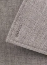 Chaqueta larga de lana 100% color gris claro, de diseño recto y doble botonadura. Cuenta con cuello de solapa con muesca, trabillas en los hombros, manga larga, dos bolsillos laterales con solapa y cinturón ajustable con hebilla. Incluye forro interior de viscosa.