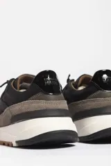 Zapatillas deportivas color crema con detalles en beige, negro y blanco.