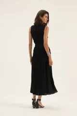 Vestido midi sin mangas confeccionado en lino color beige, con cuerpo superior ajustado mediante frunces elásticos y falda amplia con caída fluida.